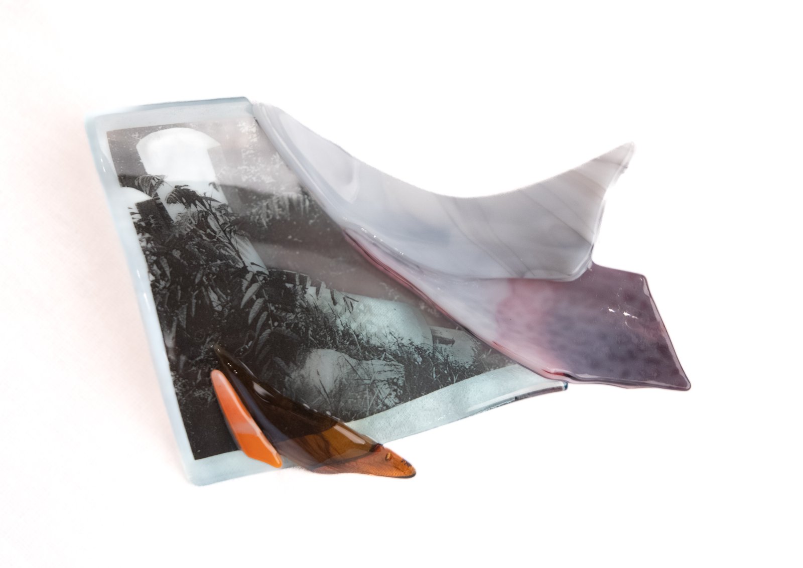 Fragments of colorful glass resting on a white background