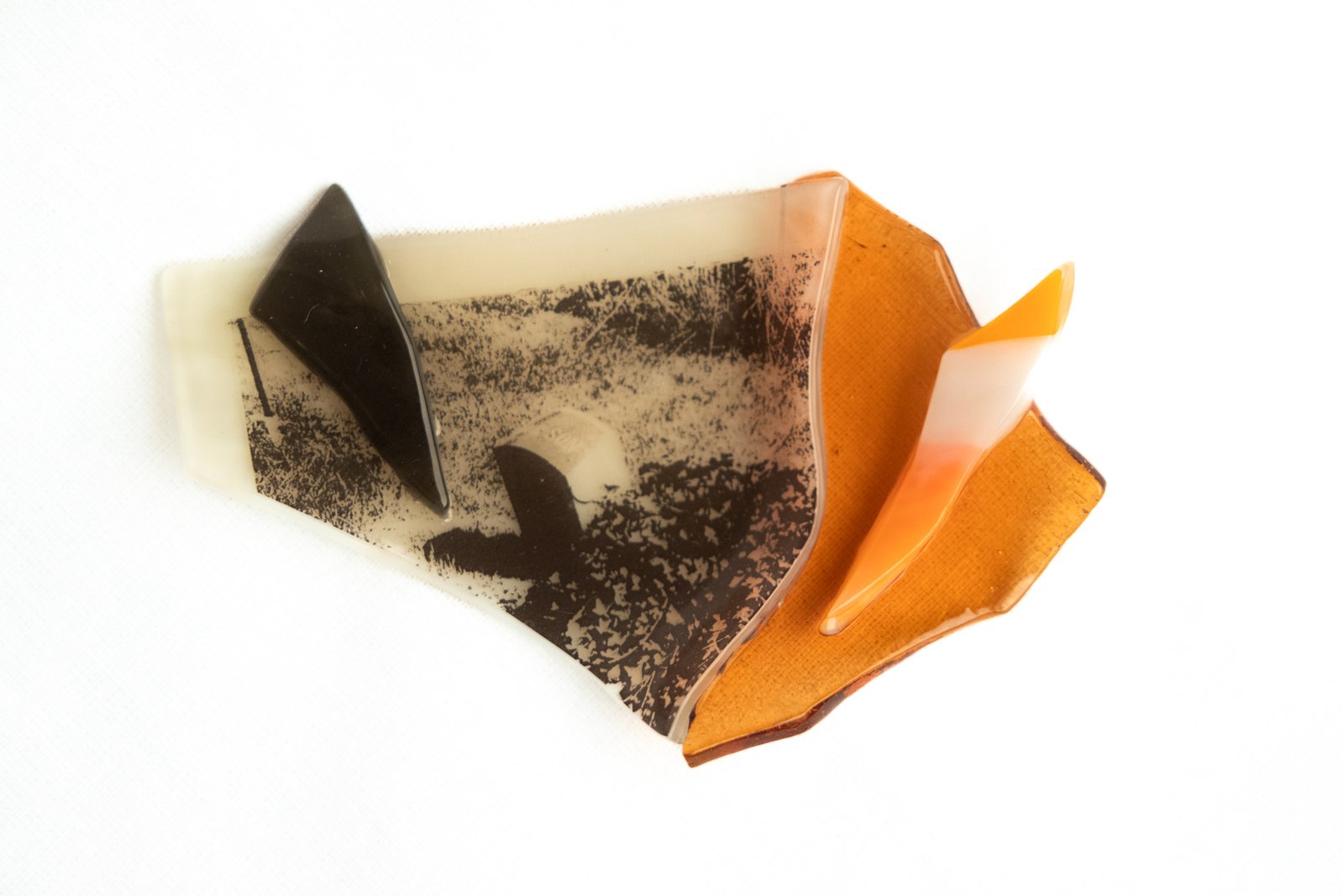 Fragments of colorful fused glass resting on a grey background
