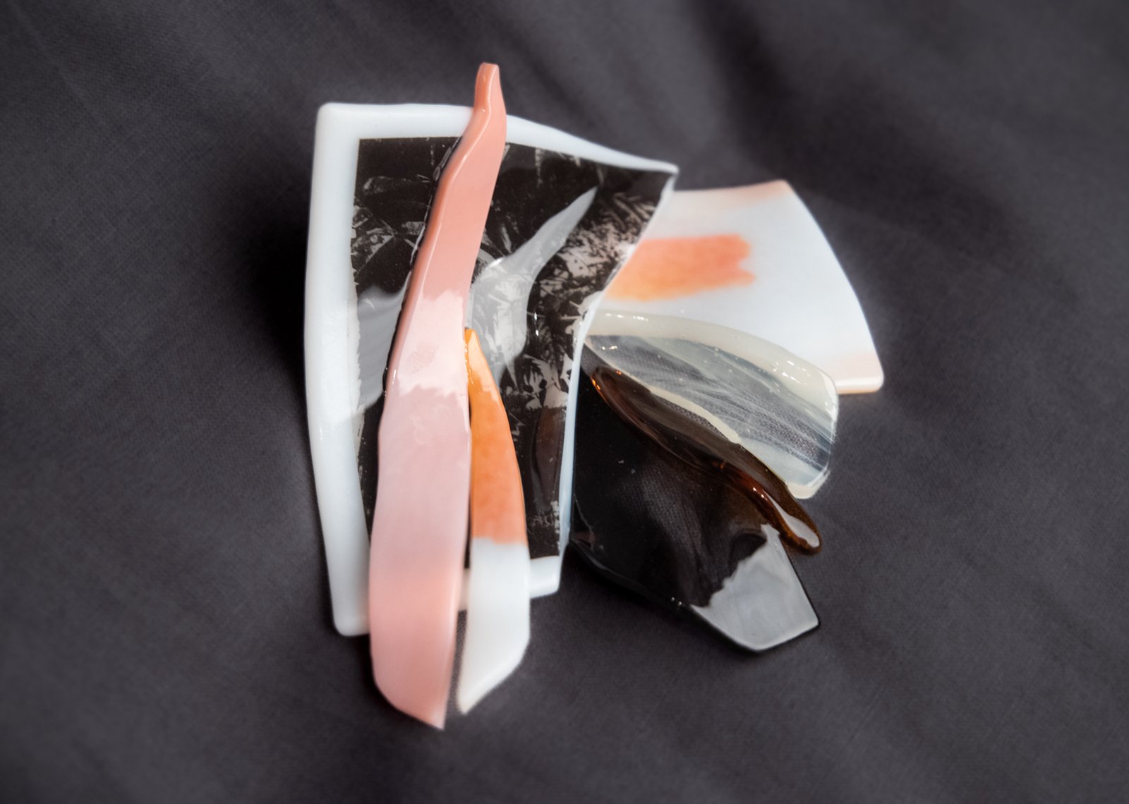Fragments of colorful fused glass resting on a grey background